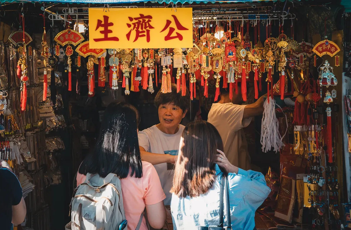元気な香港市場の様子で、人々が伝統的な観光品を購入している。